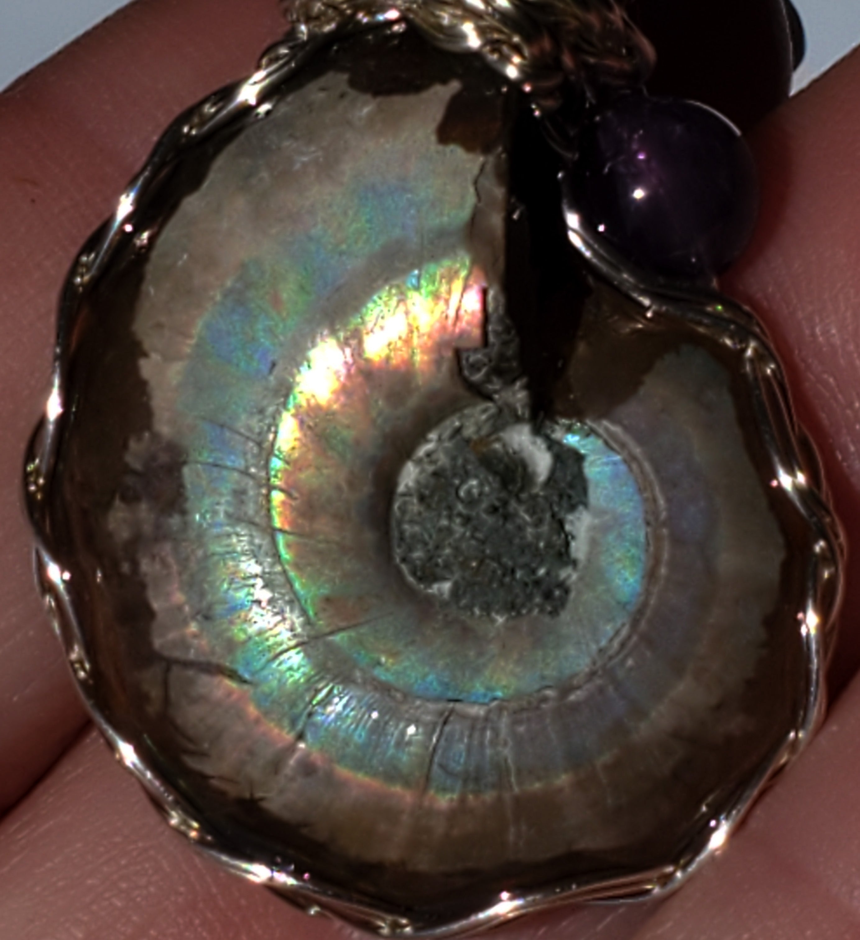 Flashy Ammonite necklace adorned with an amethyst bead